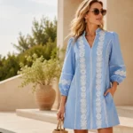 Woman wearing a light blue lace mini dress with white floral detailing styled for an elegant summer outfit