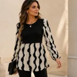 Black and cream women’s tunic top outfit featuring a long-sleeve patterned tunic styled with simple black bottoms.